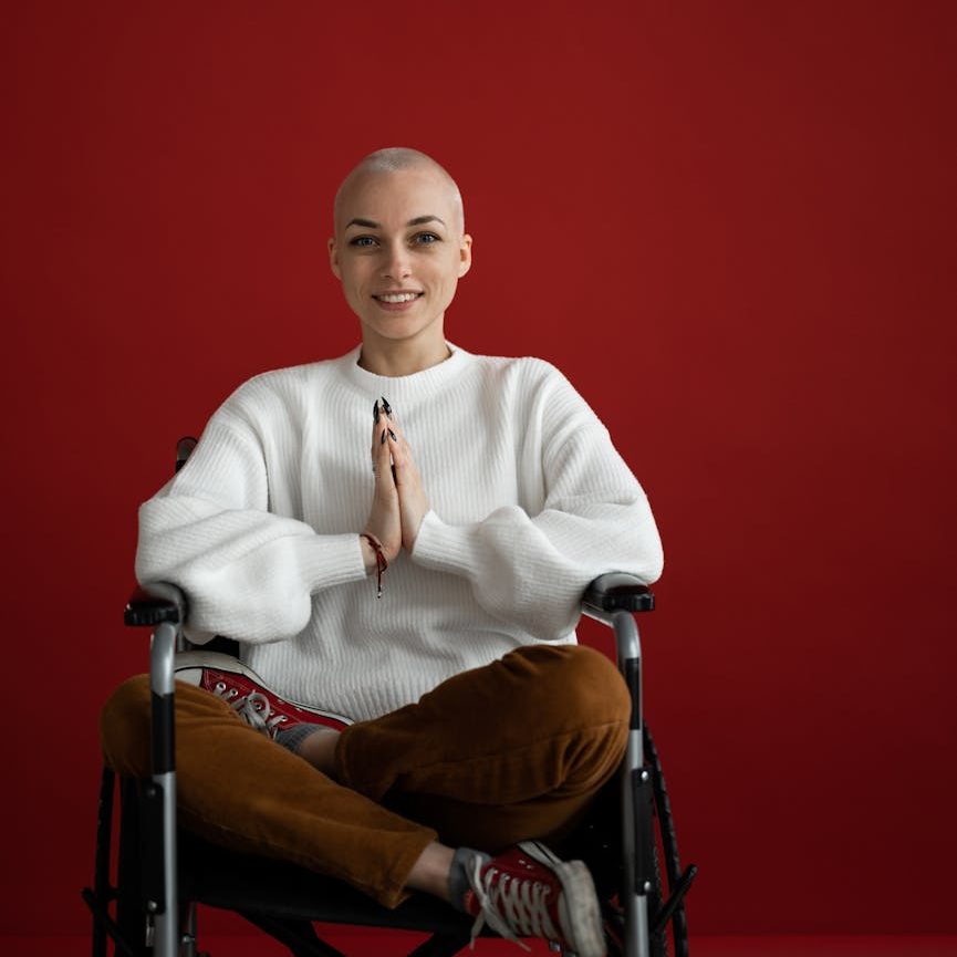 cheerful woman practicing yoga with praying hands in wheelchair