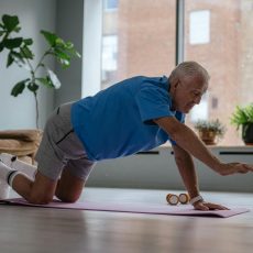 an elderly man exercising on a yoga mat
