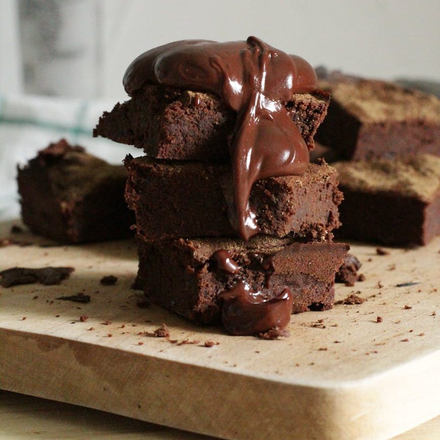 close up photo of stacked brownies on chopping board