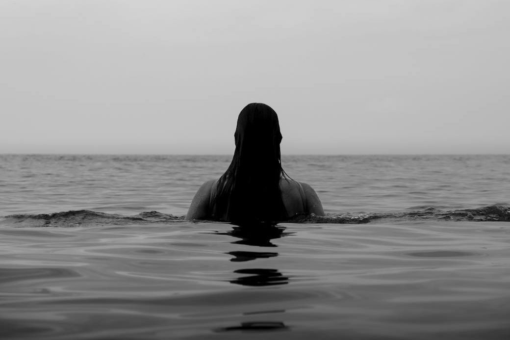 faceless woman in calm ocean water